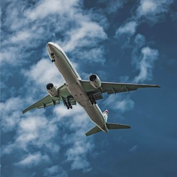 a large white airplane in a blue sky with white clouds