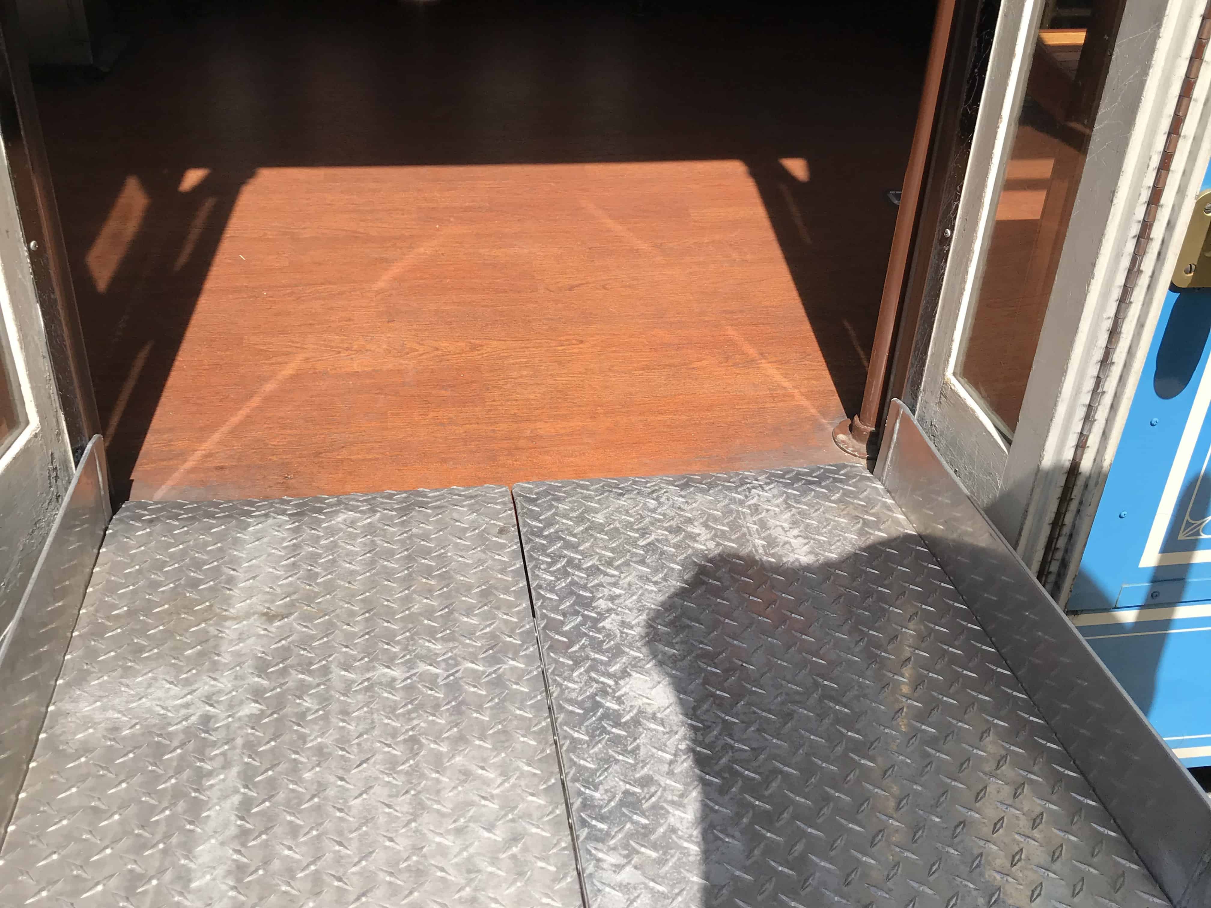 a silver ramp connects a wheelchair lift to a trolley with a reddish brown floor in Memphis