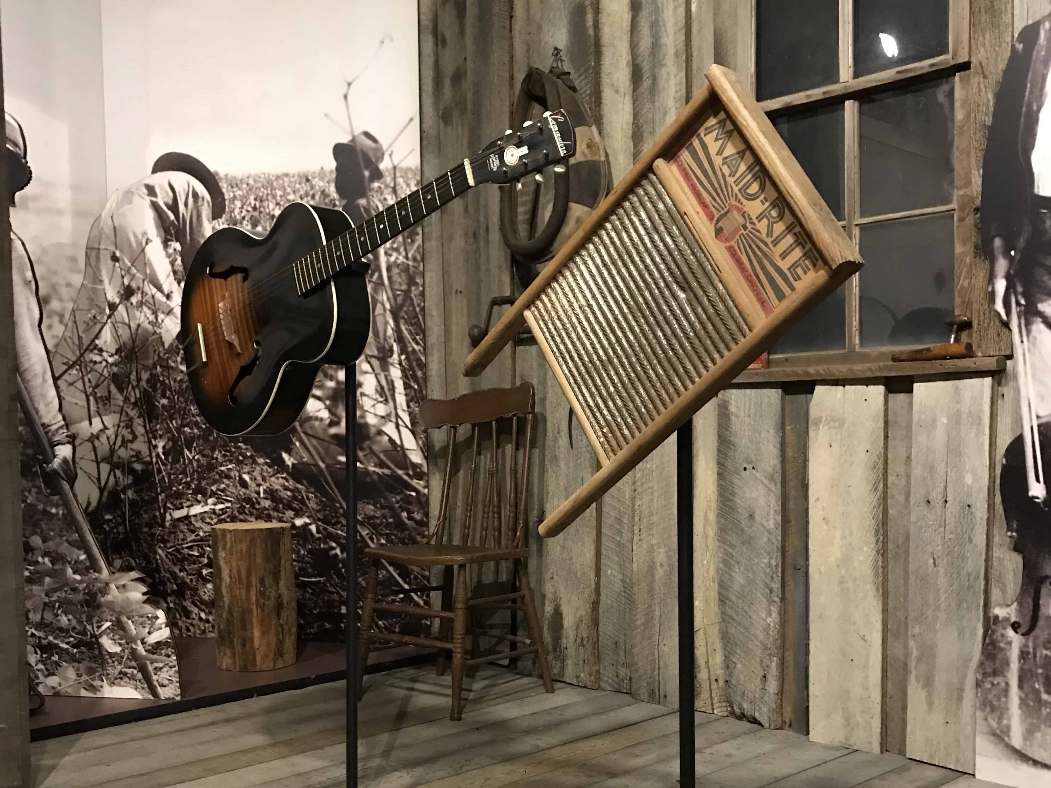 A replica of a front porch in the Tennesse country. Gray and white wood beams make up the porch. Musical instruments sit on display