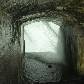 a stone tunnel leads to a tall opening behind Niagara Falls