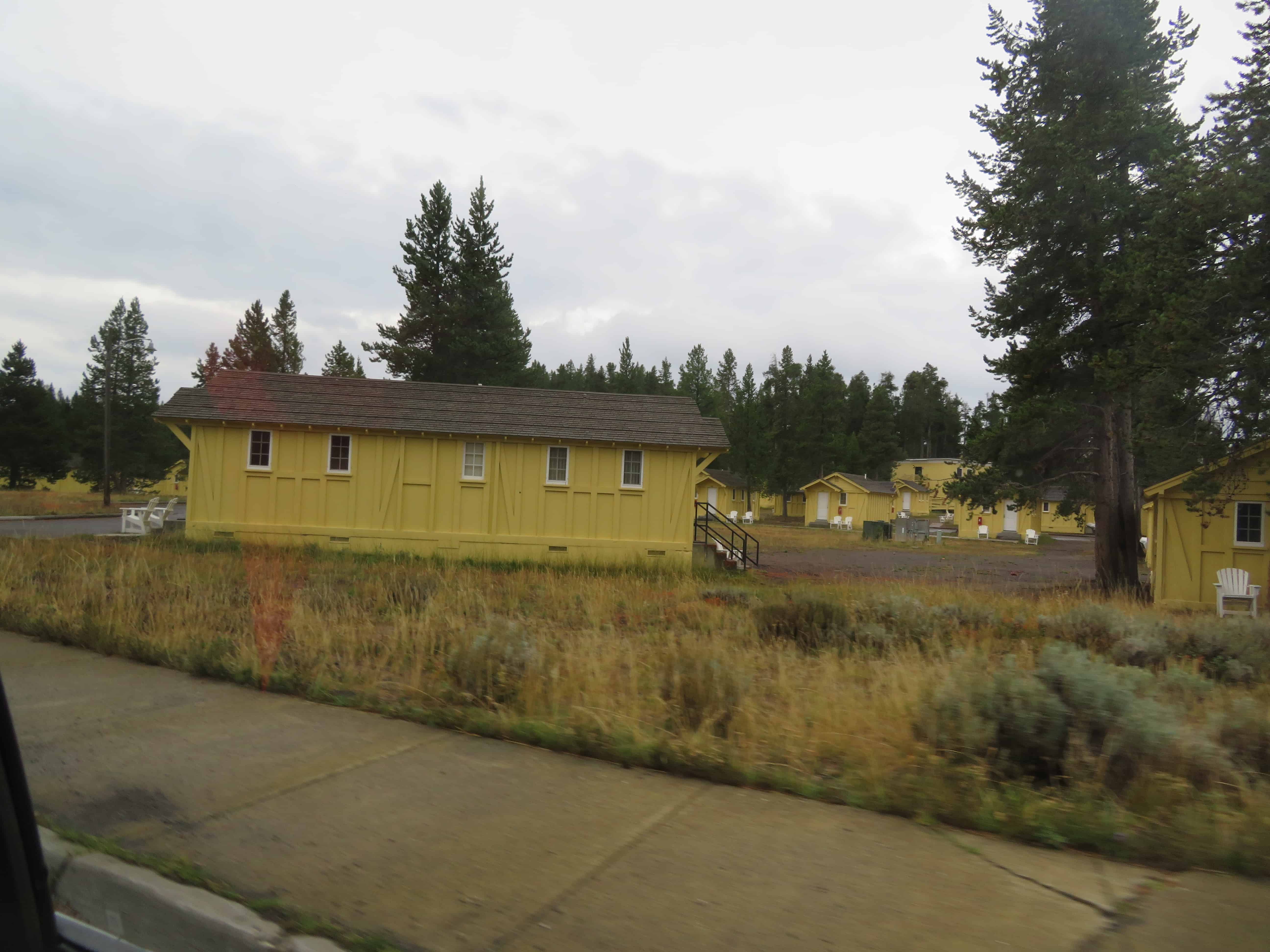 a yellow cabin available to rent inside Yellowstone National Park.  Decide whether it's worth the cost to stay inside the park when planning a trip to the national parks