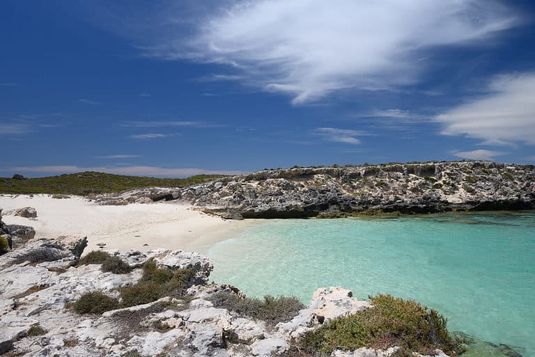 A white sand beach leads to blue green waters near Perth Australia