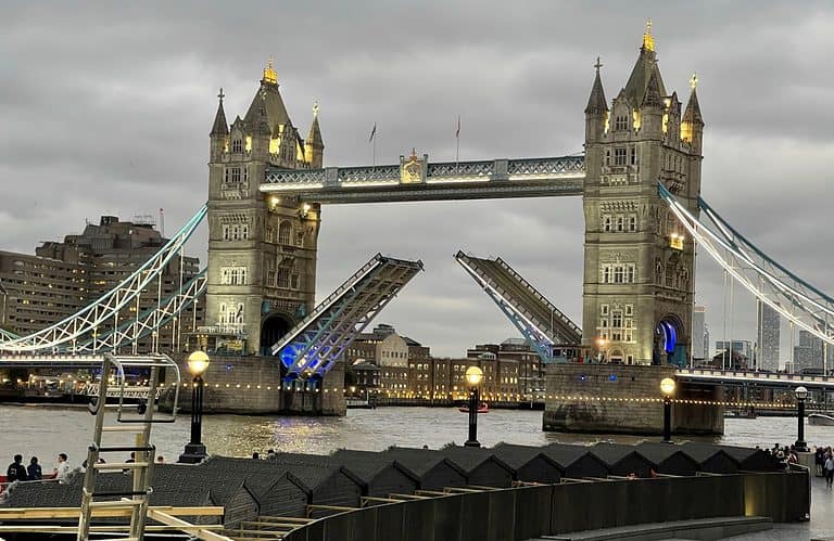 The tower bridge in London is lit up as dusk falls on the city