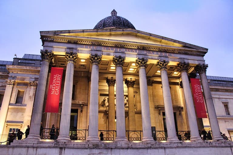 The National Gallery Museum in London is one of the best art museums in Europe and is a stone building with 8 large columns in the front and a domed roof.