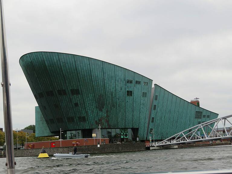 a green ship shaped building makes up the nemo science museum which is a tourist attraction in Amsterdam