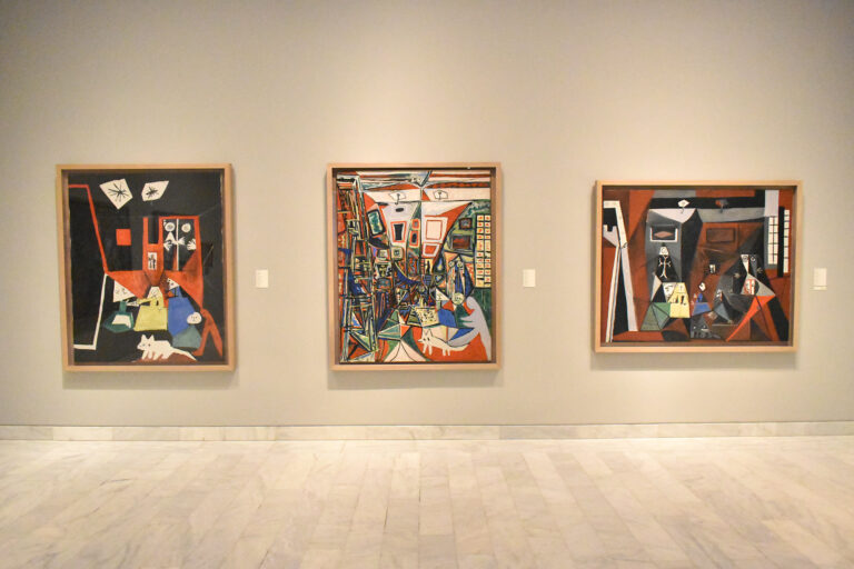 Three framed Picasso paintings hang on a beige wall in the Picasso museum in Barcelona which is one of the best art museums in Europe.