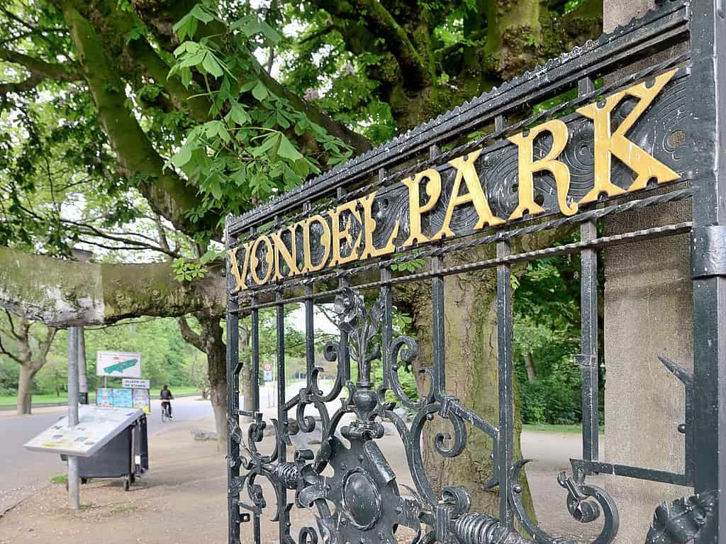 an iron gate with gold lettering says "Vondelpark" and is a popular Amsterdam tourist attraction.