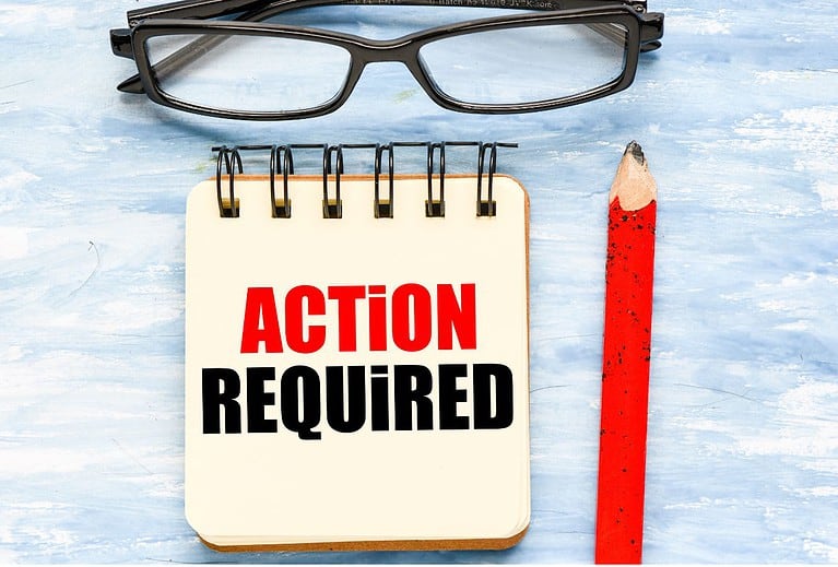 A light blue background has black eye glasses at the top with a notepad under them that says "action required" in red and black letters.  A red pencil is to the right of the notepad