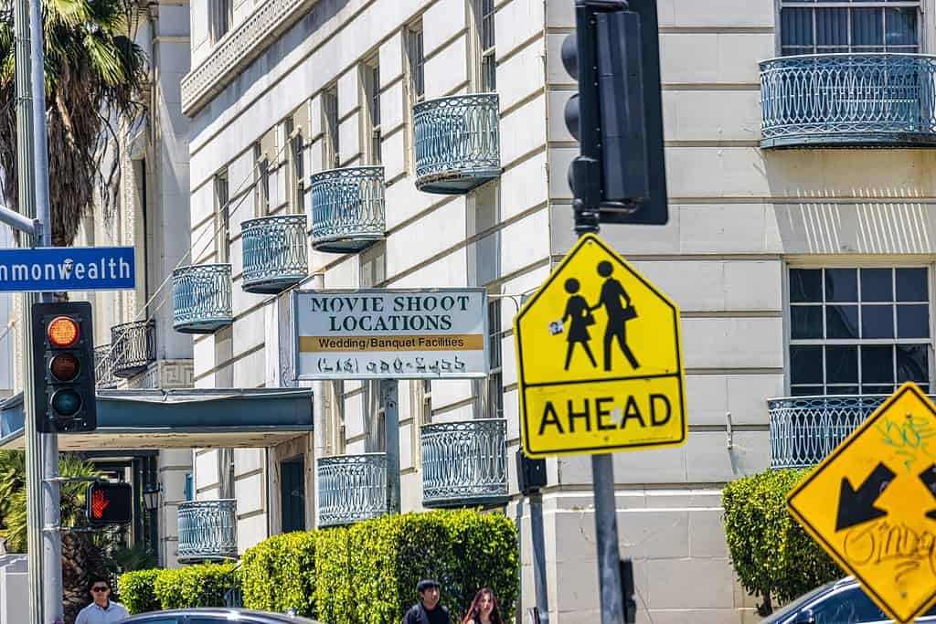 A white building in LA has a white sign sticking off of it that says Movie shoot locations.