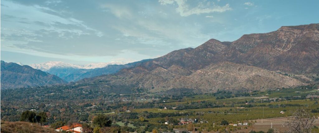 Ojai California has large mountains that surround a green valley.