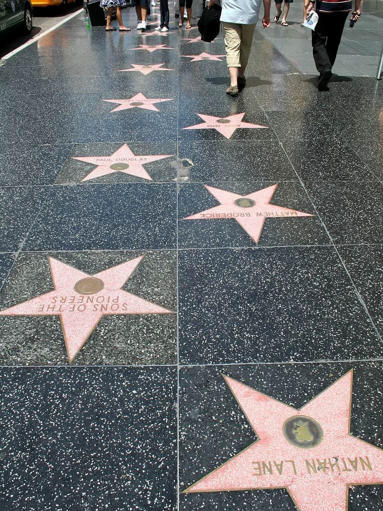 Red stars on black stone make up the Hollywood walk of fame.