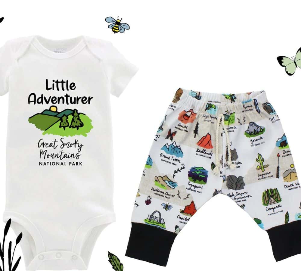 A white onsie and pants designed for a baby has the words "little adventurer" written in black writing with various national park icons.