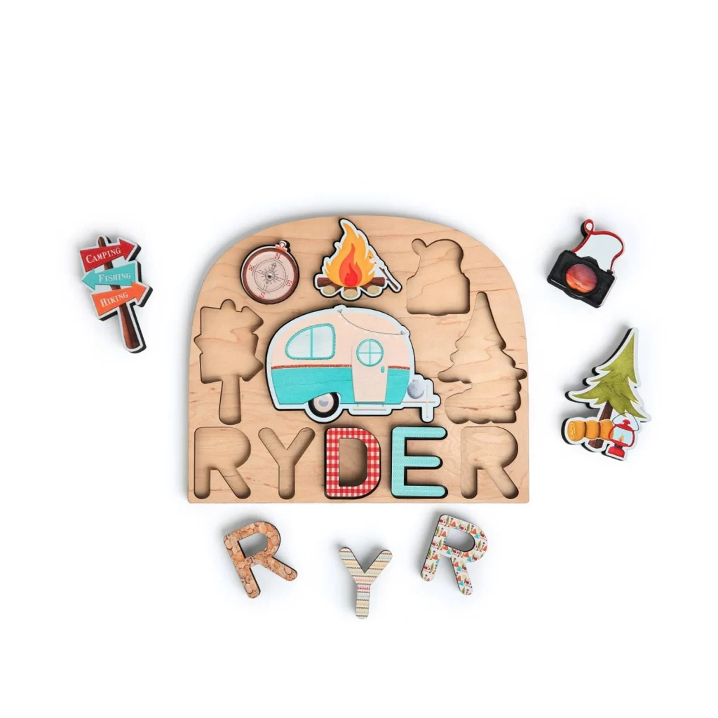 A domed wooden puzzle features symbols associated with camping in the national parks.  A child's name can be added to the bottom of the puzzle.