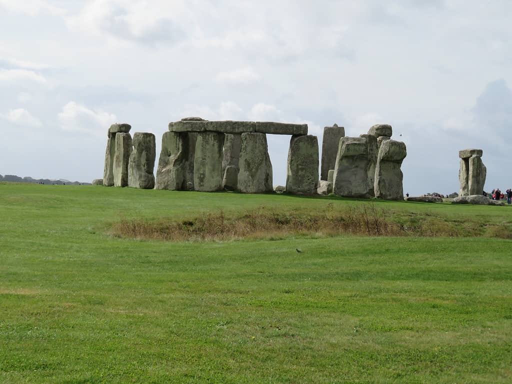 A circle of large vertical stone rocks in the middle of a green pasture makes up the iconic Stonehenge.