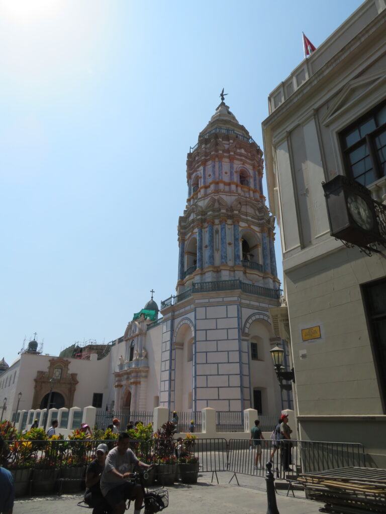 An ornate white building with blue and gold trim make up the Basilica y Monasterio de Sant Domingo exterior.