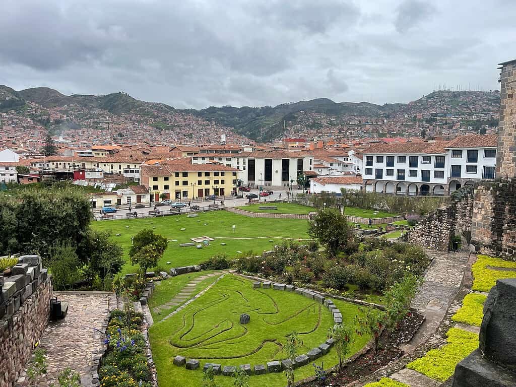 a view of the city of Cusco from an old convent which was built over Incan temples showcases white and yellow buildings with terracotta roofs.